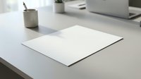 Clean white paper sheet on modern office desk with laptop and pen holder creating minimalist workspace for business presentations and documents.