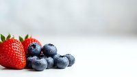 Fresh organic strawberries and blueberries on white surface for healthy eating, nutrition concepts, food photography and culinary designs.