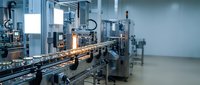 Automated production line with robotic equipment and conveyor system in modern industrial manufacturing facility for packaging and assembly operations.