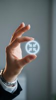 Businessman hand holding glowing Pisces zodiac sign symbol for astrology horoscope and spiritual guidance concepts.