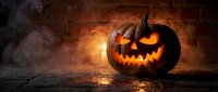 Carved jack-o-lantern pumpkin glowing with orange light against dark brick wall with atmospheric smoke and fog, suitable for seasonal decorations and holiday marketing materials.