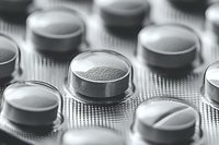 Close up macro shot of pharmaceutical pills in blister pack, showing texture and detail in black and white monochrome style for medical and healthcare concepts.
