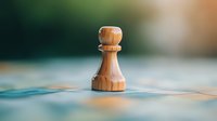 Wooden chess pawn piece standing alone on blurred blue background with soft bokeh effect, symbolizing strategy, leadership and business decisions.