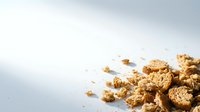 Gold nuggets and flakes scattered on white surface, symbolizing wealth, treasure, and precious metals for finance, investment, and luxury concepts.