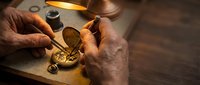 Skilled watchmaker repairing vintage pocket watch with precision tools under warm lamp light. Traditional craftsmanship and horological expertise in action.