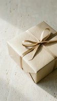 Elegant cream gift box with satin ribbon bow on textured neutral background for special occasions and celebrations.