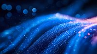 Glowing blue and pink light waves with bokeh effect and sparkles create magical abstract background for technology and science designs.
