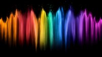 Vibrant rainbow spectrum of light streams flowing downward against black background creates dynamic motion effect with glowing multicolored energy waves.