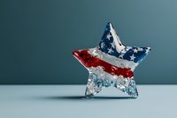 Crystal star decoration with patriotic American flag colors of red, white and blue stripes against neutral background, elegant holiday decor element.