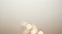 Soft beige background with warm golden bokeh lights creating dreamy atmosphere for elegant design projects and romantic presentations.