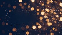 Golden bokeh lights scattered across dark blue background creating magical atmosphere for holiday celebrations and festive occasions.