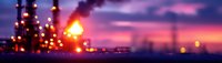 Defocused industrial refinery lights glowing against dramatic purple and orange sunset sky, creating atmospheric bokeh effect at dusk.