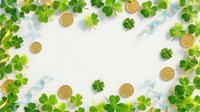 St. Patrick's Day frame with green shamrocks, gold coins and ribbons on white background for festive holiday decorations and greeting cards.