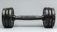 Old rustic black metal dumbbell with worn texture and scratches on light background, vintage style gym equipment for strength training and fitness.