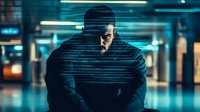 Hooded figure in dark urban environment with glowing cyber lines effect, creating mysterious atmosphere against blurred neon city background.