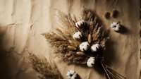 Rustic autumn bouquet with dried pampas grass and cotton stems on neutral linen fabric background for seasonal home decor and wedding arrangements.
