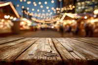 Rustic wooden table with festive holiday market blurred in background, string lights creating warm atmosphere for seasonal celebrations.