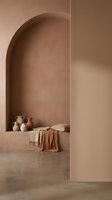 Minimalist terracotta interior with arched niche displaying ceramic pottery and textile on concrete floor for modern home decor and architectural design projects.