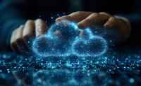 Glowing digital cloud symbol with particles floating above hands in dark background, representing cloud computing technology and digital transformation.