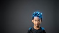 Young boy with East Asian ethnicity wearing dark clothing, featuring striking electric blue glowing spiky hair effect against neutral gray background. Suitable for education, creativity, innovation, technology concepts.