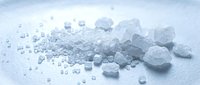 Pile of crushed ice cubes and frozen water crystals scattered on white surface, suitable for beverage, food, cooling and refrigeration concepts.