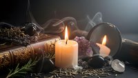 Mystical altar setup with burning candles, crystals, herbs and ancient books creating atmospheric spiritual scene for meditation and ritual practices.