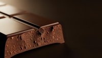 Premium dark chocolate bar with textured surface and rich cocoa finish for gourmet food photography and culinary marketing materials.