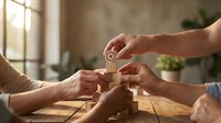 Diverse hands collaborating to build wooden block tower in bright modern office space representing teamwork and business strategy development.