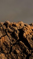Rich brown soil clods with natural texture and earthy tones for agriculture and gardening projects.