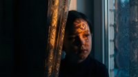 Mysterious man with dramatic lighting peering through ornate doorway in dark atmospheric interior setting for thriller and suspense concepts.