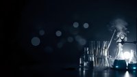 Laboratory glassware with smoke and bokeh lights on dark background for scientific research and chemistry experiments.