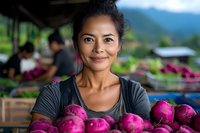 Asian woman vendor smiling at local farmers market holding fresh purple dragon fruit. Traditional produce seller at outdoor marketplace with exotic tropical fruits.
