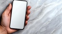 Hand holding modern smartphone with blank white screen against marble or granite texture background, mockup for app or website presentation.