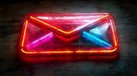 Glowing neon mail envelope sign in red, pink and blue colors against dark background, modern communication symbol for business and marketing designs.