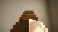 Wooden blocks stacked in pyramid formation with light and shadow contrast, representing growth, success, and business progression for corporate presentations.