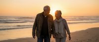 Senior couple walking hand in hand on beach at sunset, romantic golden hour moment by ocean waves, elderly man and woman enjoying peaceful evening stroll together.