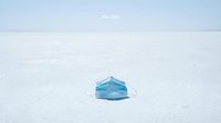 Blue medical face mask lying on vast white salt flat with stay safe text, symbolizing pandemic health protection and safety awareness.