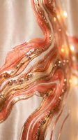 Luxurious coral and gold marble texture with sparkling glitter accents and warm bokeh lights creating elegant abstract background for premium design projects.