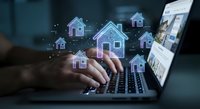 Digital real estate technology concept with glowing house icons floating above laptop keyboard for property management and online housing market solutions.