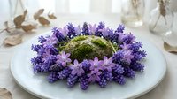 Fresh lavender flowers arranged in decorative circle around moss ball on white plate for spa relaxation aromatherapy home decor natural wellness display.