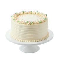 Elegant vanilla layer cake with cream frosting, piped borders, and pastel floral decorations on white pedestal stand for celebrations and bakery designs.