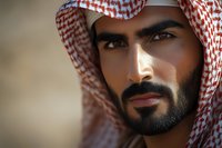 Middle Eastern man wearing traditional red and white keffiyeh headscarf with well-groomed beard in close-up portrait showing cultural heritage and traditional dress.
