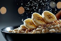 Healthy breakfast bowl with sliced banana, granola and nuts with flying ingredients on dark background for morning meal advertising.