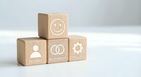 Wooden blocks with customer service icons including smiley face, user symbol, relationship rings and management gear on white background.