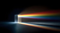 Light spectrum dispersing through glass prism creating rainbow colors on dark background for physics education and optical science concepts.