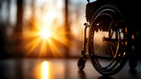 Silhouette of empty wheelchair against sunset with golden sunburst rays shining through forest, creating hopeful atmosphere for healthcare and accessibility themes.