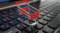 Shopping cart on laptop keyboard symbolizing online retail and e-commerce business concept, digital marketplace for internet shopping.