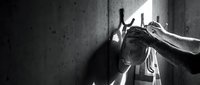 Young woman covering face with hands in distress against concrete wall. Mental health, depression, anxiety, emotional pain concept for therapy materials.