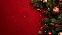 Festive Christmas composition with fir branches, red and gold ornaments, and berries on rich red textured background with copy space for holiday designs.