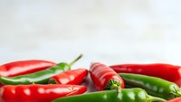 Fresh red and green chili peppers arranged on white background for culinary cooking spice ingredient food photography kitchen design cooking recipes.